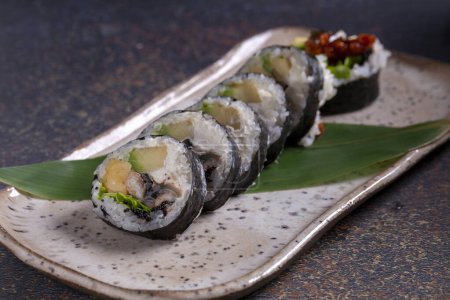 Téléchargez les photos : Délicieux rouleau de sushi, servi sur une assiette colorée avec des épices - en image libre de droit