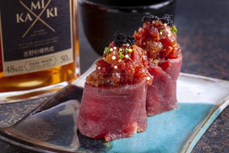 Téléchargez les photos : Thon sashimi sur une assiette bleue avec une bouteille de saké - en image libre de droit