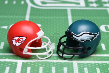 Foto de IRVINE, CALIFORNIA - 30 Jan 2023: Football helmets of the Kansas City Chiefs vs Philadelphia Eagles, opponents in Superbowl LVII, on a gridiron background. - Imagen libre de derechos