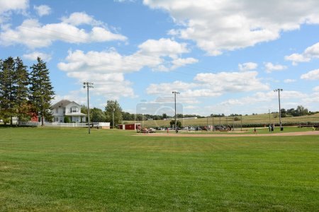 Photo for DYERSVILLE, IOWA - AUGUST 20, 2015: Field of Dreams movie set. Children and adults playing baseball on the diamond of the 1989 movie set. - Royalty Free Image
