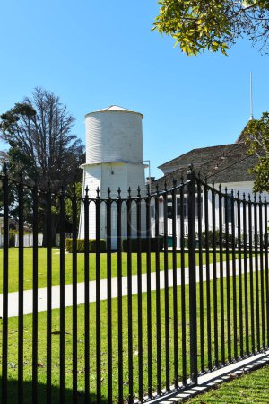 Foto de HUNTINGTON BEACH, CALIFORNIA - 02 MAR 2023: Newland House Museum fence and water tank, the oldest residence in HB and listed on the National Register of Historic Places. - Imagen libre de derechos