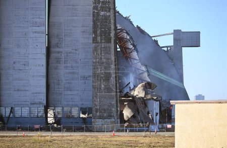 Téléchargez les photos : TUSTIN, CALIFORNIE - 13 NOV 2023 : Le feu du hangar à dirigeables Tustin MCAS, gros plan et toujours en train de fondre alors que le mur nord brûle lentement. - en image libre de droit