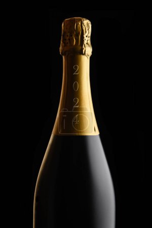New Years Concept. Closeup of an unopened bottle of Champagne with the year 2024 on the foil, against a black background. 