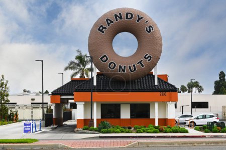 Foto de COSTA MESA, CALIFORNIA - 25 FEB 2024: Randys Donuts en Harbor Boulevard, con su icónico donut gigante encima del edificio. - Imagen libre de derechos