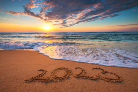 Téléchargez les photos : Bonne année 2023 concept, lettrage sur la plage. Texte écrit sur la plage au lever du soleil. - en image libre de droit