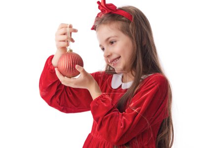 Foto de Mujer sonriente con bolas brillantes árbol de Navidad, niña posando en vestido rojo de Santa Claus sobre fondo blanco - Imagen libre de derechos