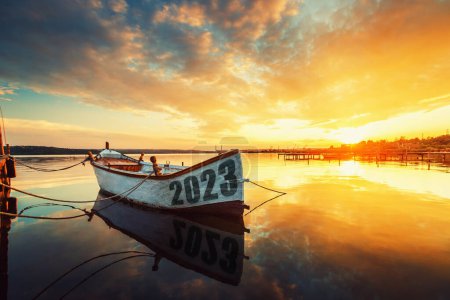 Foto de 2023 feliz año nuevo concepto. Barco de pesca en el lago de Varna con un reflejo en el agua al atardecer. Naturaleza paisaje. - Imagen libre de derechos