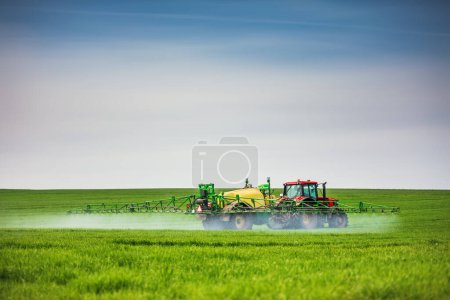 Photo for Tractor spray fertilizer spraying pesticides on green field, agriculture background concept. - Royalty Free Image