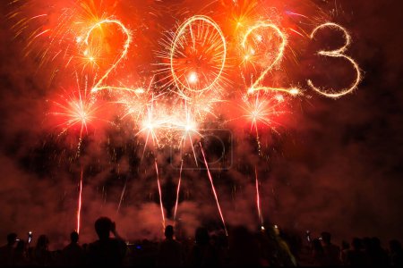 Foto de 2023 feliz año nuevo fuegos artificiales y bengalas en la bandera del cielo de medianoche. Chispas, fuegos artificiales, luces y gente de fiesta de celebración - Imagen libre de derechos