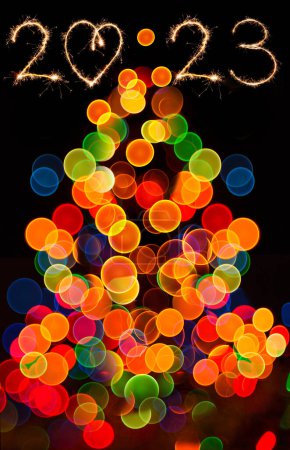 Foto de Bokeh circular abstracto de la luz de Navidad. Luces Bokeh sobre fondo negro. Feliz año nuevo 2023 y árbol de Navidad. - Imagen libre de derechos