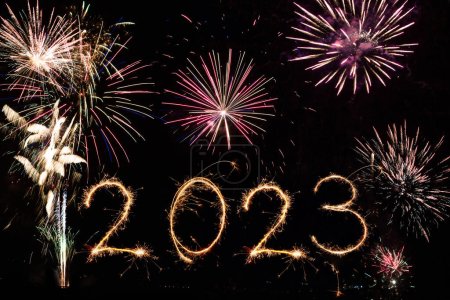 2023 Happy New Year eve text of Sparkle firework on black night sky. Fireworks and illumination celebration.