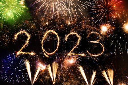 2023 Frohes Neues Jahr geschrieben mit Glitzerfeuerwerk und Wunderkerzen auf schwarzem Hintergrund. Nachthimmel um Mitternacht an Heiligabend, Jubiläumsbeleuchtung
