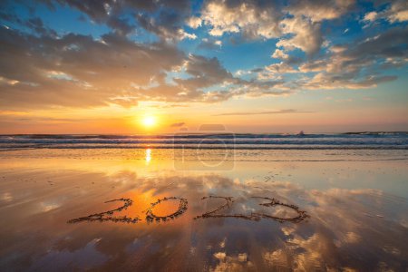 Foto de Feliz Año Nuevo 2023 concepto, letras en la playa. Texto escrito en la playa al amanecer. - Imagen libre de derechos