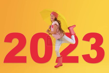 Téléchargez les photos : Nouvel an 2023 concept de Fille avec des bottes en caoutchouc fond jaune. Mode de vie, voyage, concept shopping. - en image libre de droit