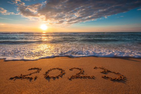 Foto de Océano playa amanecer y texto Feliz año nuevo 2023 en la arena de la costa. Puesta de sol marina. - Imagen libre de derechos