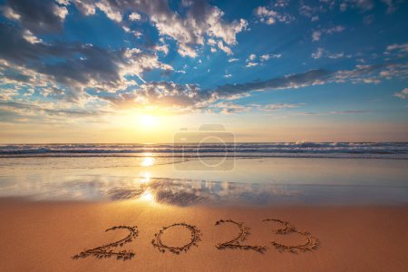 Foto de Feliz Año Nuevo 2023 concepto, letras en la playa. Texto escrito en la playa al amanecer. - Imagen libre de derechos
