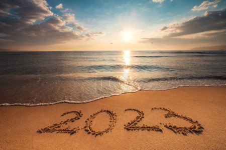Téléchargez les photos : Bonne année 2023 concept, lettrage sur la plage. Texte écrit sur la plage au lever du soleil. - en image libre de droit