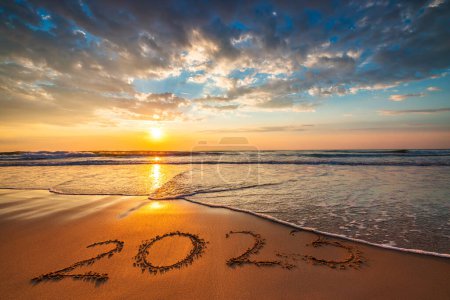 Foto de Feliz Año Nuevo 2023 concepto, letras en la playa. Texto escrito sobre la arena del mar al amanecer. - Imagen libre de derechos