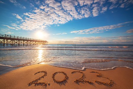 Téléchargez les photos : New Year 2023 beach sunrise. Text 2023 in sea sand, nature ocean landscape - en image libre de droit