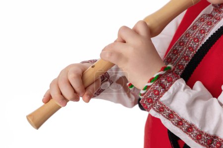 Photo for Bulgarian boy musician with flute in traditional folklore costume with martenitsa symbol of spring, Baba Marta and Easter holiday, portrait on white background - Royalty Free Image