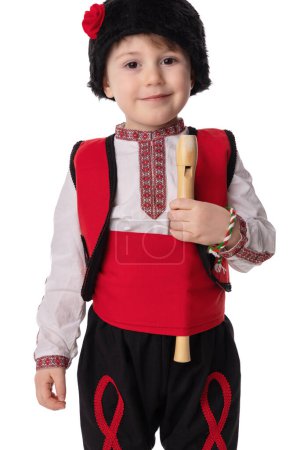 Bulgarian boy in traditional ethnic folklore costume, martenitsa and wooden flute, Bulgaria. Baba Marta holiday