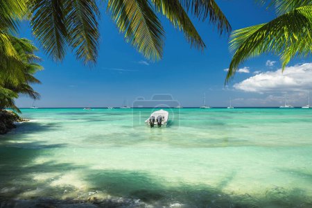 Foto de Hermoso mar caribeño y barco en la orilla de la exótica isla tropical, vista panorámica desde la playa - Imagen libre de derechos
