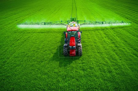 Photo for Aerial view of farming tractor plowing and spraying on field. - Royalty Free Image