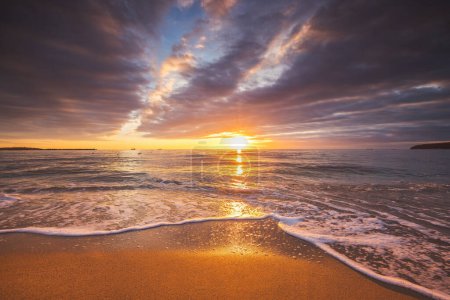 Téléchargez les photos : Couleur lever de soleil sur la plage. Belle matinée avec un paysage nuageux sur le bord de la mer. - en image libre de droit