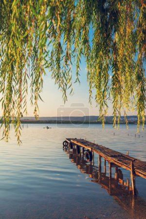 Téléchargez les photos : Sunset over the sea lake and old wooden pier, romantic travel destination, nature landscape - en image libre de droit