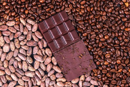 Foto de Barra de chocolate negro ecológico, plumas de cacao y granos de café como fondo - Imagen libre de derechos