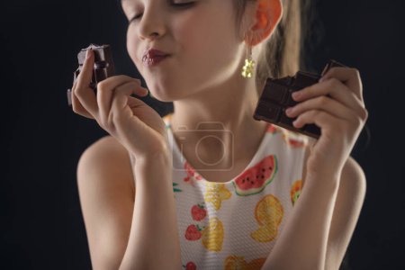 Foto de Chocolate y retrato de mujercita bastante hambrienta. Hermosa chica lista para comer barra de chocolate. - Imagen libre de derechos