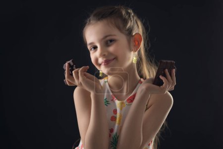 Foto de Chocolate y retrato de niña bastante hambrienta. Hermosa chica lista para comer barra de chocolate. - Imagen libre de derechos