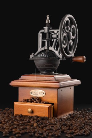 Foto de Mezclador molinillo de café vintage con granos de café y humo de aroma aislado sobre fondo negro - Imagen libre de derechos