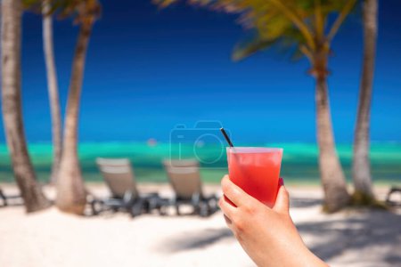 Foto de Playa exótica isla con palmeras en la orilla del mar Caribe y refrescante cóctel de verano pina colada - Imagen libre de derechos