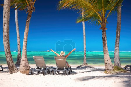 Foto de Playa isla exótica con palmeras y tumbonas en la orilla del mar Caribe, vacaciones tropicales de verano. - Imagen libre de derechos