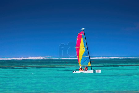 Photo for People on a color catamaran sailboat or winsurf sailing in calm caribbean sea, summer vacation and sport - Royalty Free Image