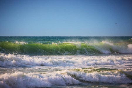 Téléchargez les photos : Grandes vagues océaniques, vague de lever de soleil vert et paysage nuageux au-dessus de l'eau de mer - en image libre de droit
