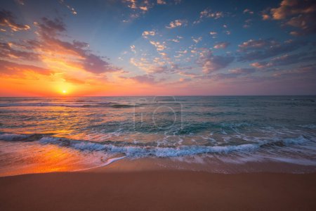 Foto de Hermoso paisaje nublado sobre el agua y la playa, salida del sol sobre el horizonte del mar - Imagen libre de derechos