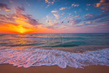 Foto de Océano amanecer sobre la playa y las olas. El sol se levanta sobre el horizonte del mar - Imagen libre de derechos