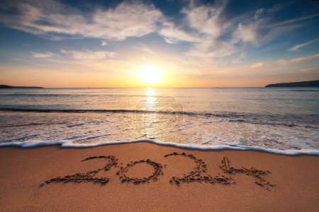Foto de Feliz Año Nuevo 2024 concepto, letras en la playa. Texto escrito en la playa al amanecer. - Imagen libre de derechos