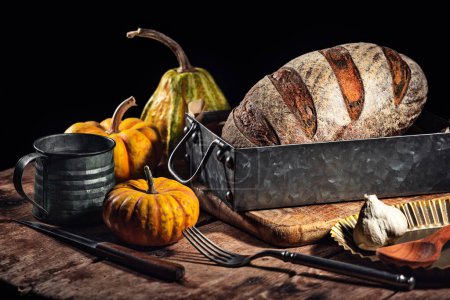 Téléchargez les photos : Four à pain au levain croustillant fait maison fait avec du blé, du charbon actif, des épices à la citrouille et au curcuma et assaisonner les aliments d'automne dans la cuisine - en image libre de droit