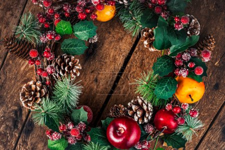 Téléchargez les photos : Couronne de Noël sur fond de bois rustique. Décoration de Noël avec espace de copie pour le texte - en image libre de droit