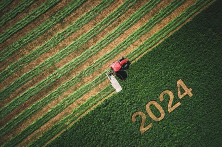 Téléchargez les photos : 2024 Happy Ney Concept d'usure et tracteur rouge fauchage champ vert. - en image libre de droit