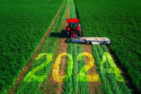 Foto de 2024 Feliz Año Nuevo concepto y tractor agrícola siega campo verde vista aérea. - Imagen libre de derechos