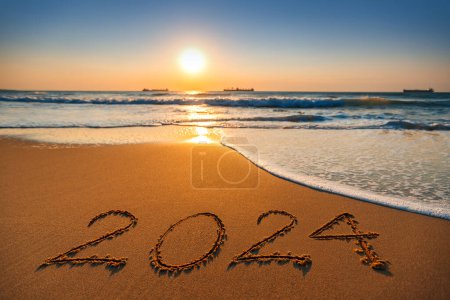 Foto de Feliz Año Nuevo 2024 concepto, letras en la playa. Salida del sol del mar. - Imagen libre de derechos