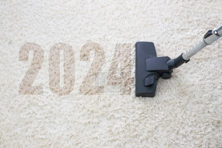 Foto de Limpieza del hogar con aspiradora y espacio de copia para un texto, año nuevo 2024 - Imagen libre de derechos