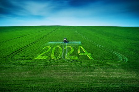 Foto de 2024 Feliz Año Nuevo concepto y vista aérea de la agricultura tractor arado y pulverización en el campo. - Imagen libre de derechos