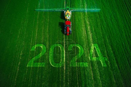 Foto de 2024 Feliz Año Nuevo concepto y vista aérea de la agricultura tractor arado y pulverización en el campo. - Imagen libre de derechos