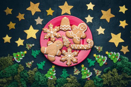 Téléchargez les photos : Biscuits de pain d'épice de Noël d'un homme, flocon de neige, cloche, étoile, concept d'arbre d'une veille de Noël avec pleine lune dans une forêt, Joyeux Noël et joyeux fond de vacances - en image libre de droit