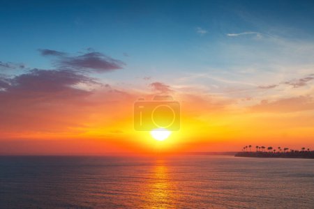 Téléchargez les photos : Beau paysage nuageux sur l'eau de mer et la côte, coup de soleil levant - en image libre de droit
